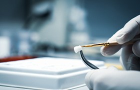 A lab worker processing a dental crown