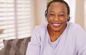 Smiling woman with dental implant-retained dentures