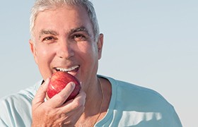 Older man biting into an apple