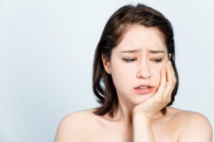 Woman holding her face from jaw pain
