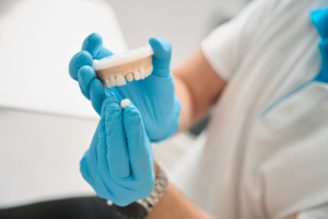 Close up of dentist handling a model dental crown